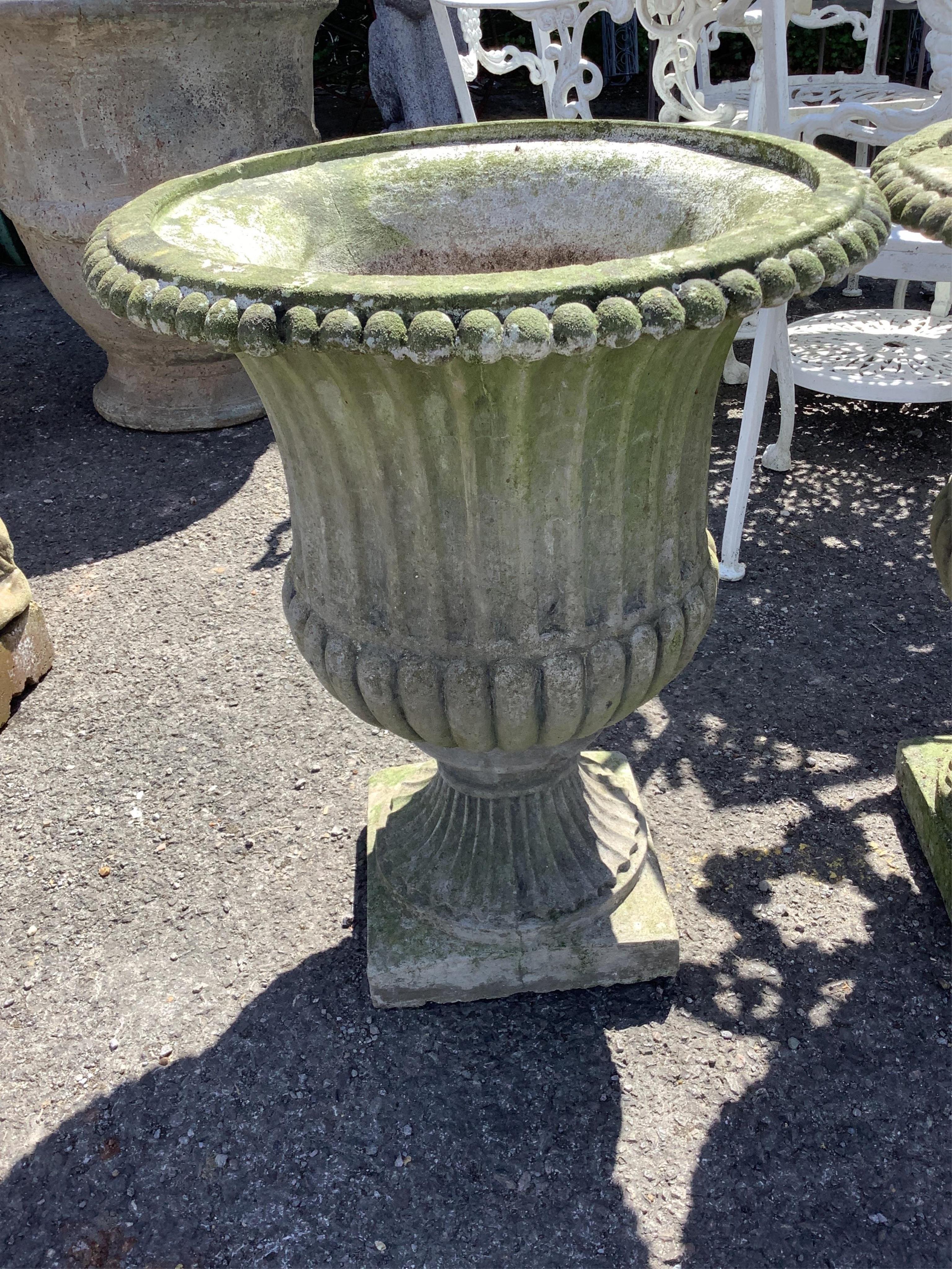 A pair of reconstituted stone campana garden urns on pedestal bases, diameter 46cm, height 58cm